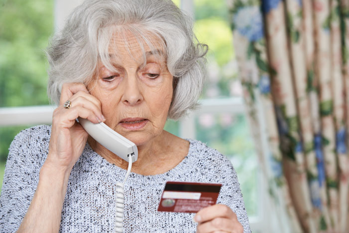 senior woman giving credit card details over the phone